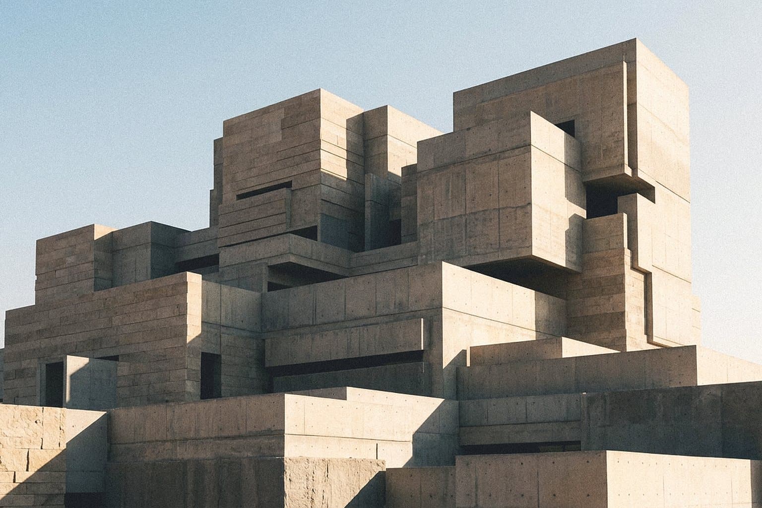 Stepped stone volumes of a fortress-like building in hard sunlight