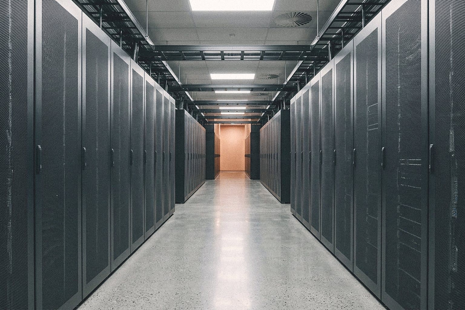 Empty data centre aisle between rows of server racks