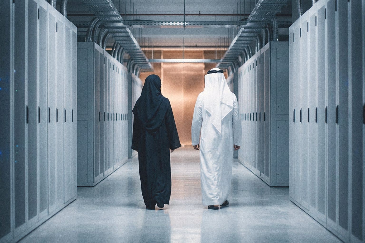 Two engineers walking away down a data centre aisle